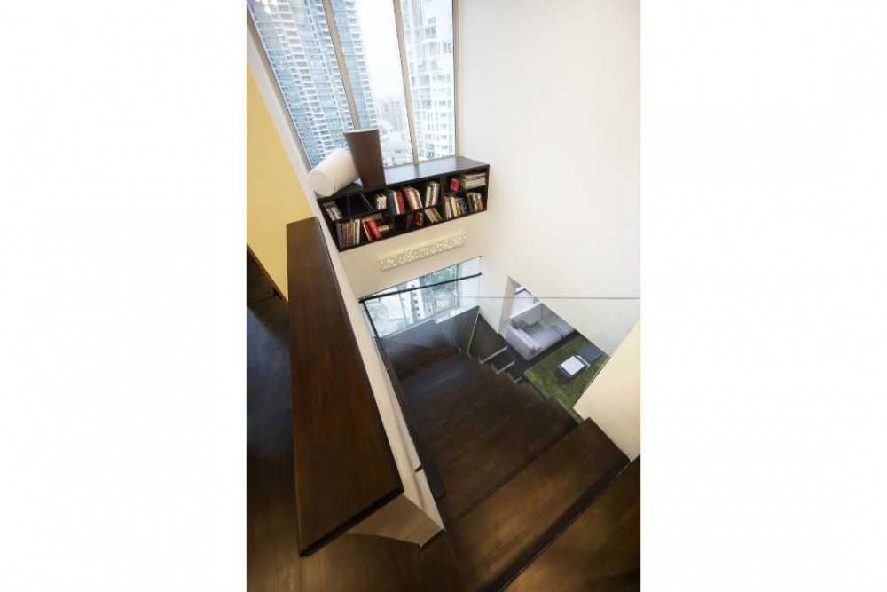 Eclectic Hallway with Bookshelf and Staircase