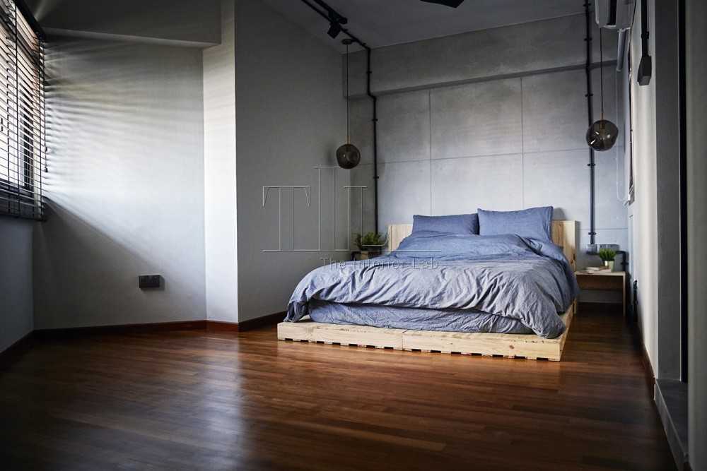 Industrial Bedroom with Wood Flooring and Feature Wall