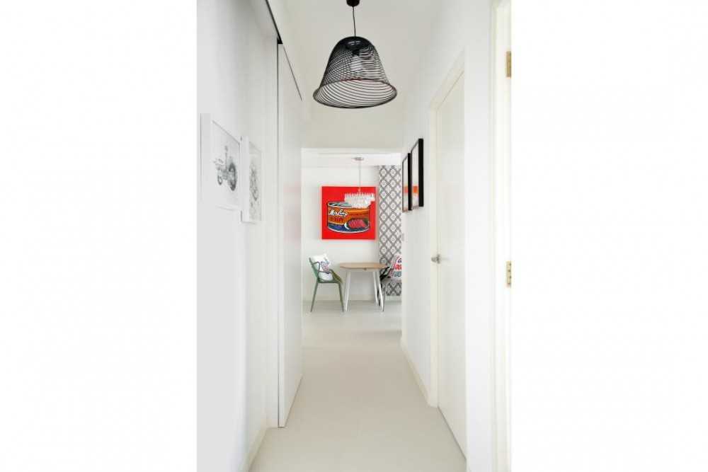 Transitional Hallway with Paintings and Lighting