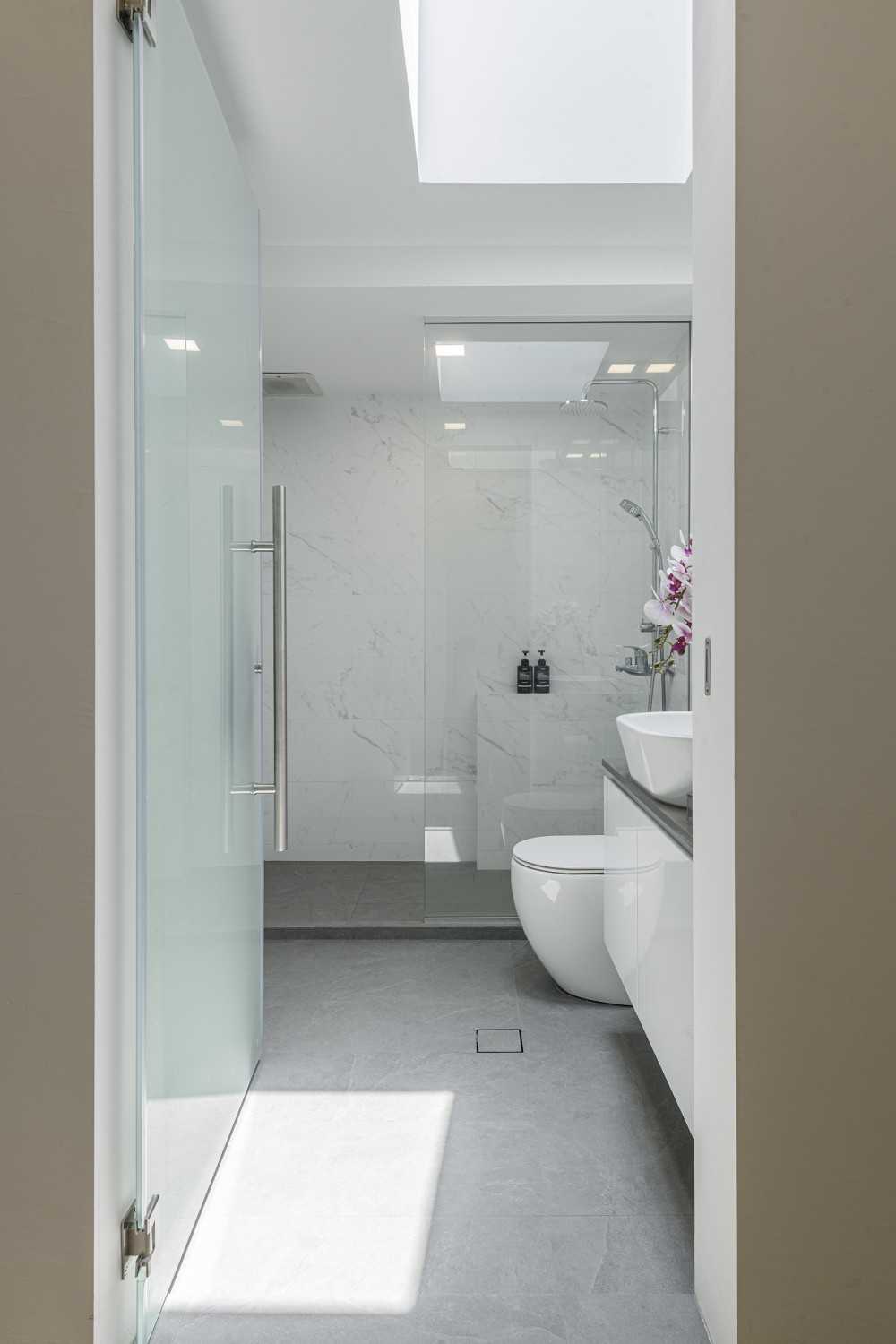 Minimalist Bathroom with Homogeneous Tiles and Parquet Floor