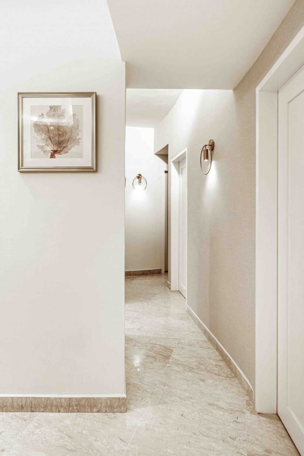 Transitional Hallway with Bookshelf and Artwork