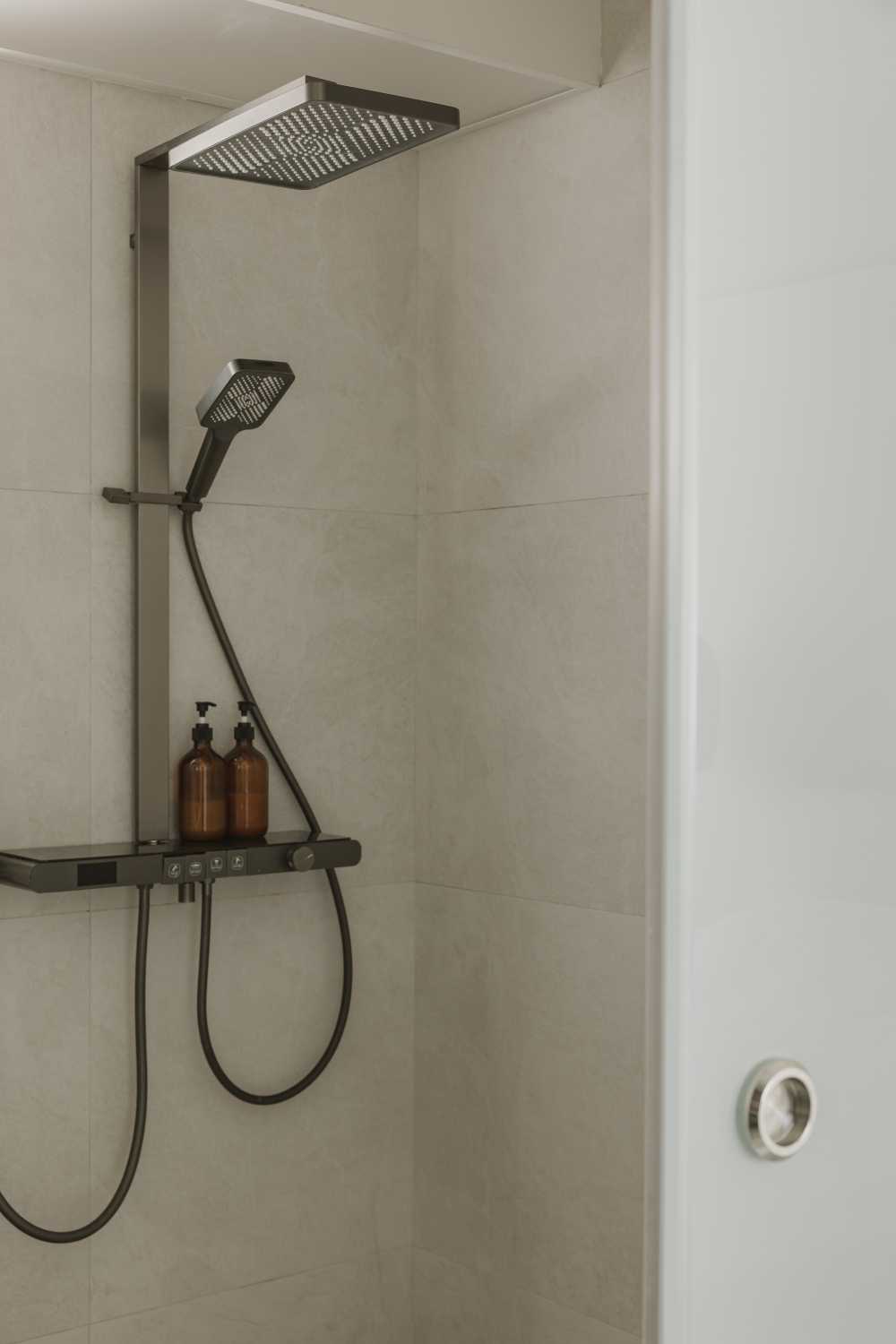 Minimalist Bathroom with Homogeneous Tiles and Rainshower