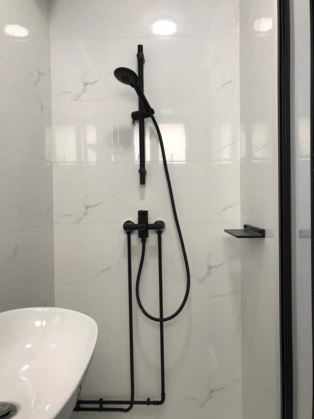 Minimalist Bathroom with Homogeneous Tiles and Showers