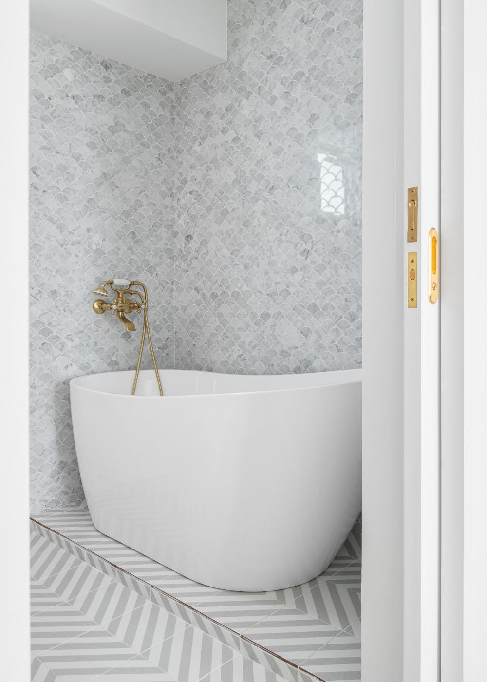 Minimalist Bathroom with Herringbone Tiling and Bathtub