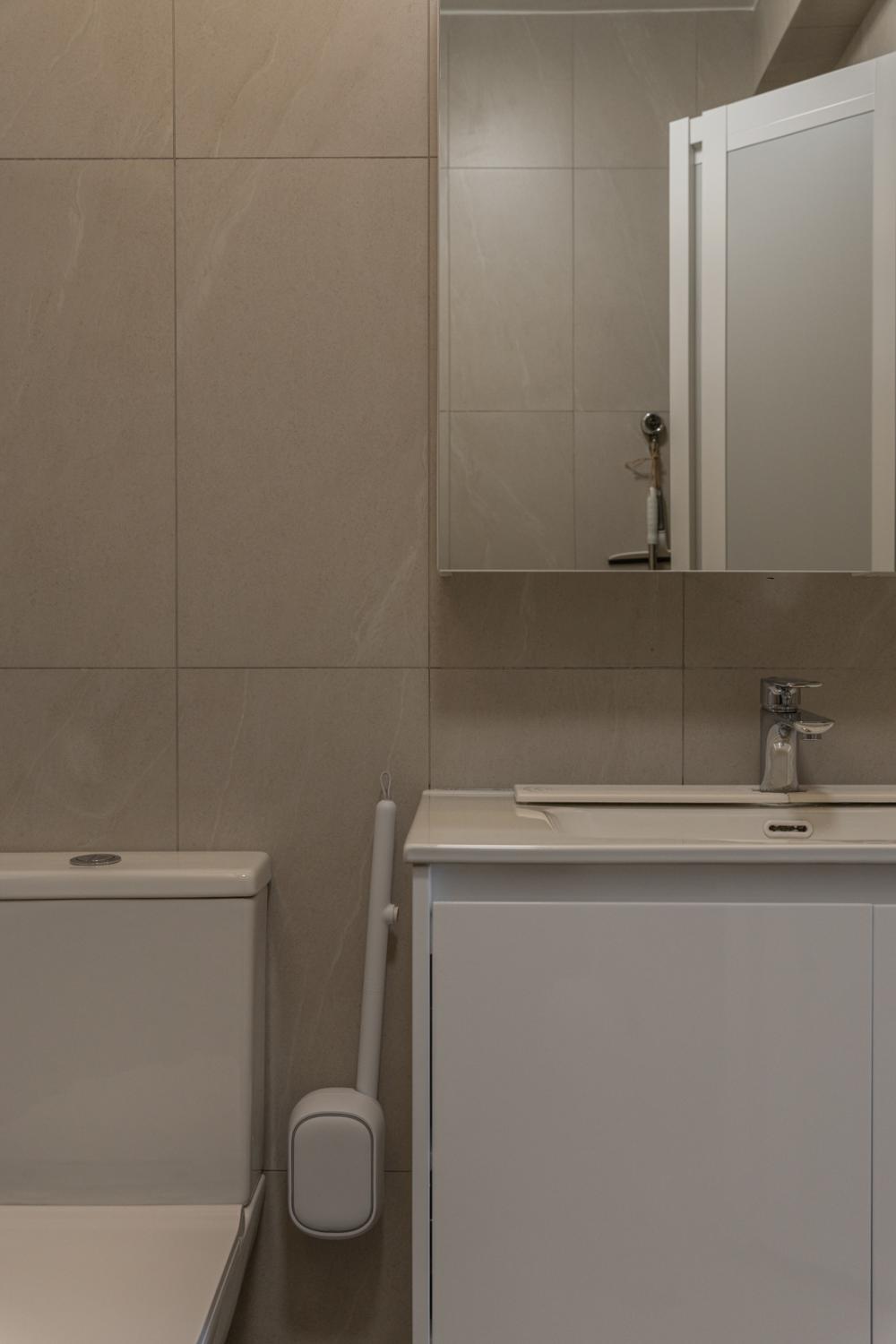 Minimalist Bathroom with Homogeneous Tiles and Mirror