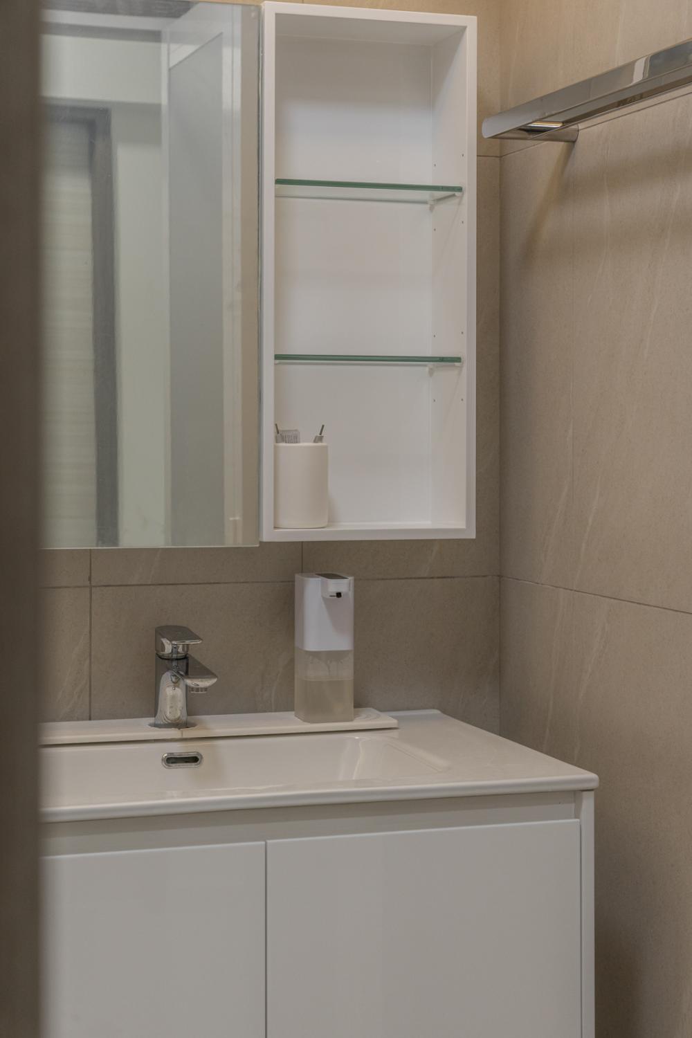 Minimalist Bathroom with Homogeneous Tiles and Mirror