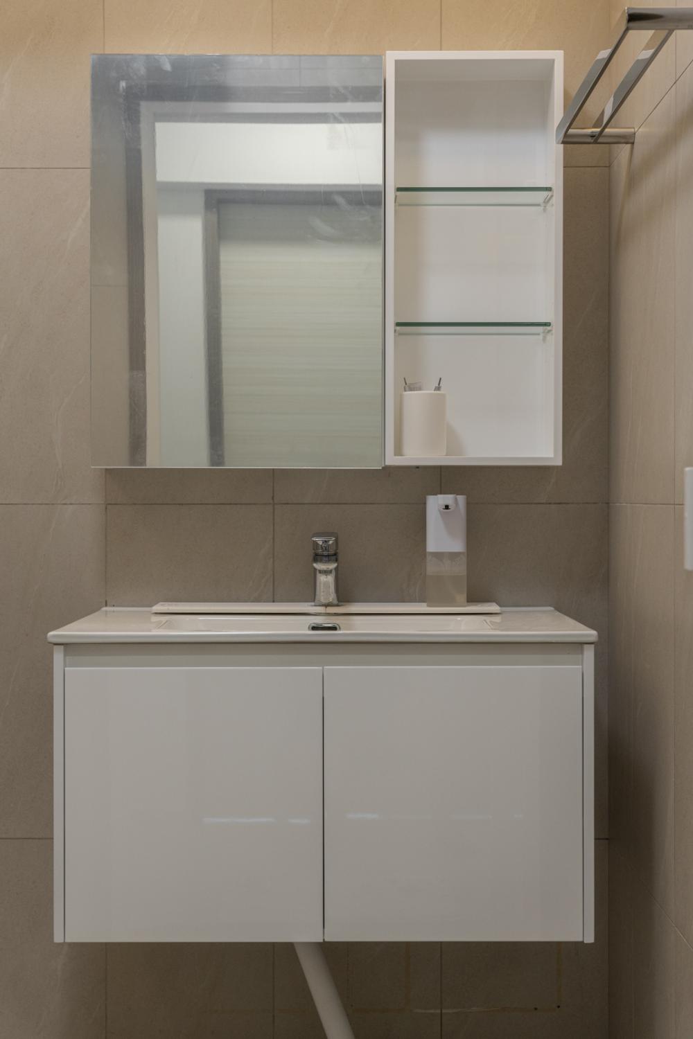 Minimalist Bathroom with Homogeneous Tiles and Mirror