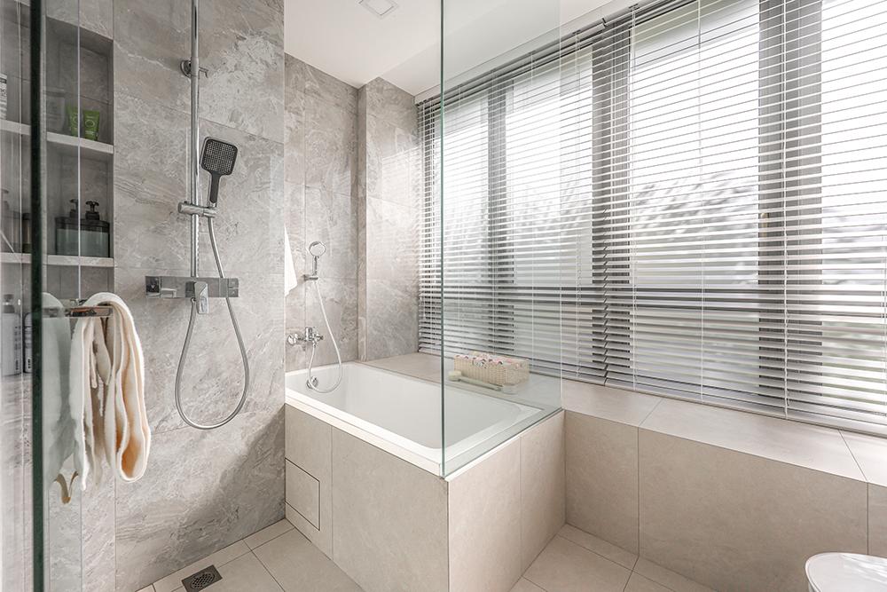 Minimalist Bathroom with Homogeneous Tiles and Bathtub