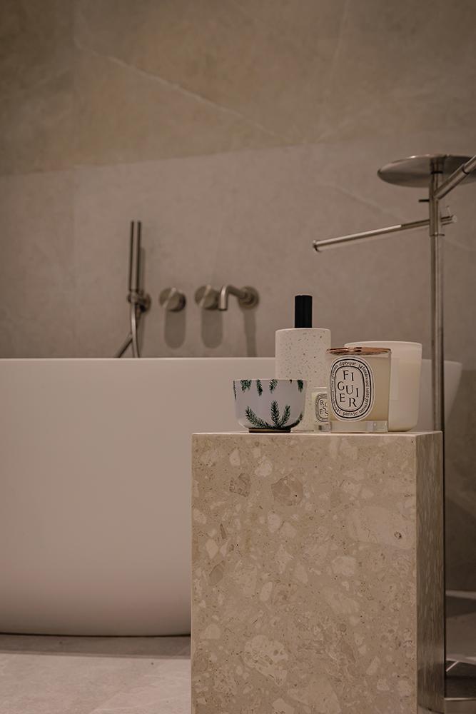 Minimalist Bathroom with Homogeneous Tiles and Bathtub