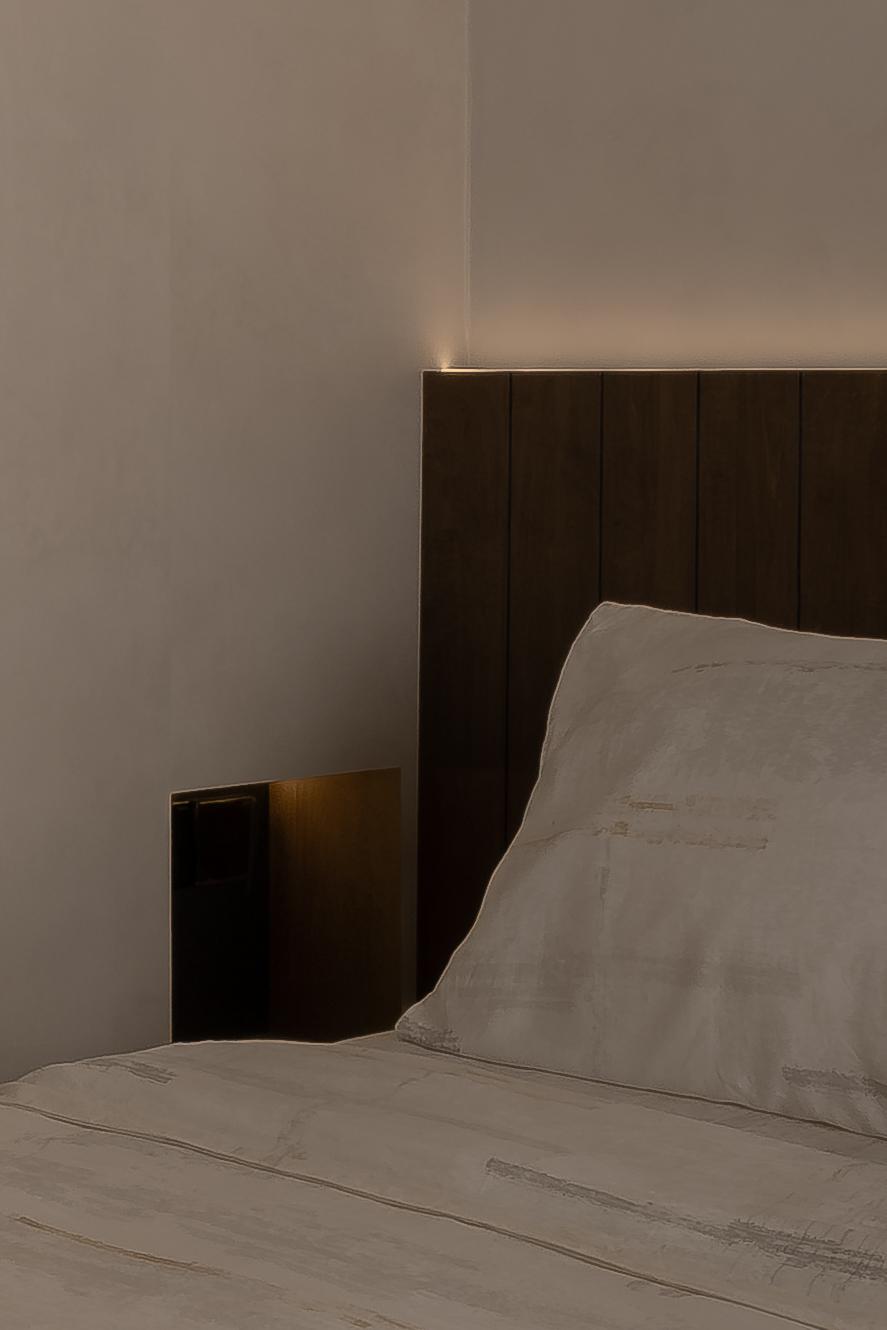 Minimalist Bedroom with Cove Lighting and Bedside Table